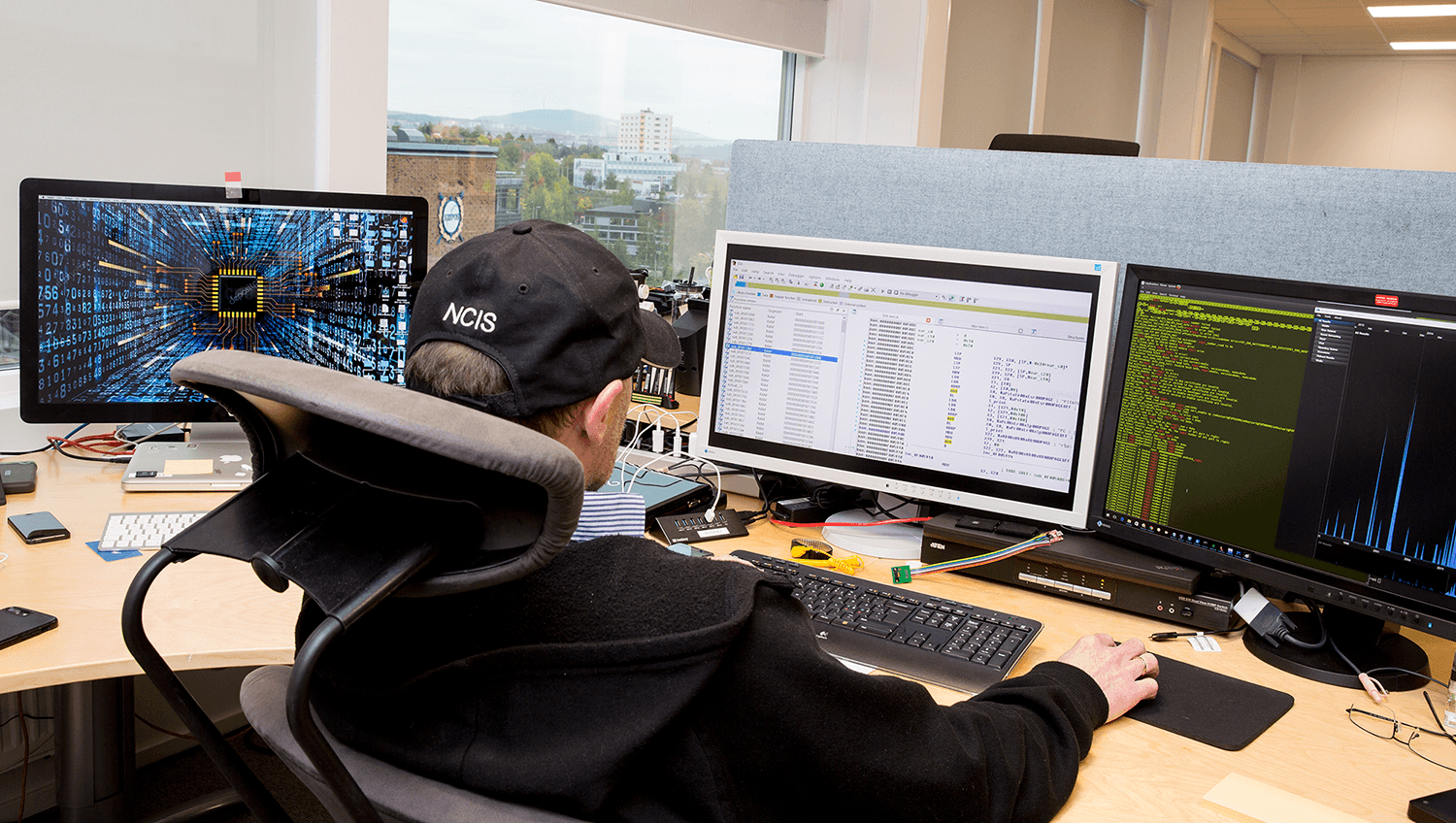 Ansatt ved E-spor sitter foran flere dataskjermer